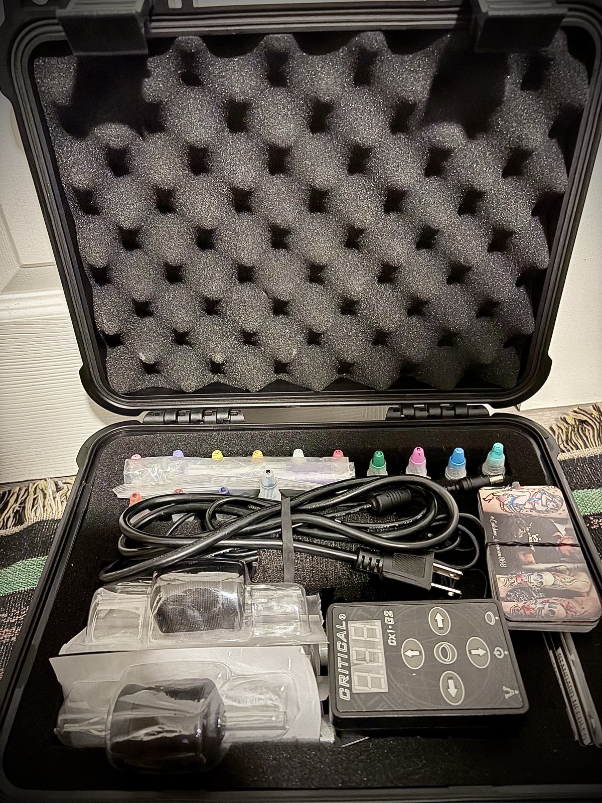 Kevin Mokuahi's tattoo kit — power supply, ink caps, RCA cord, cartridges inside a Pelican case