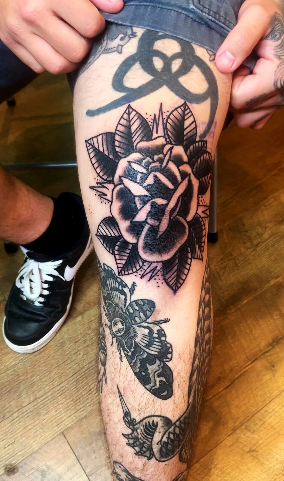 Black and grey traditional black rose with leaves knee tattoo by Tim Goodrich, Waikiki, Hawaii