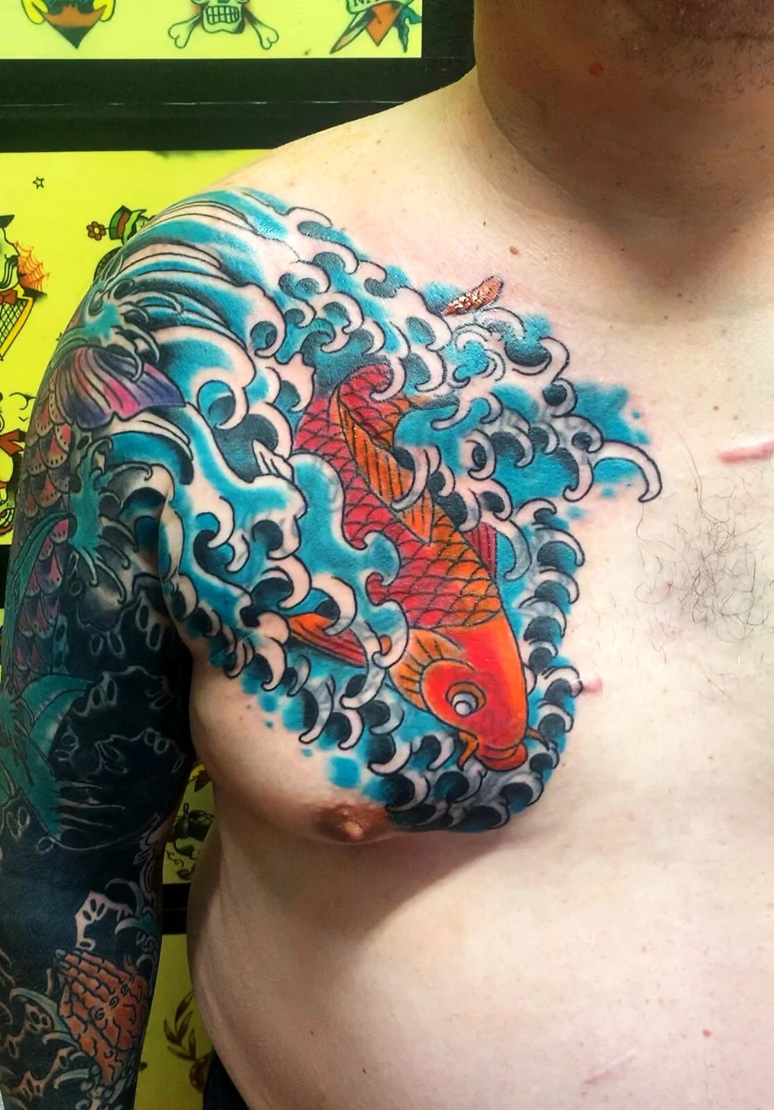 Japanese Wabori orange koi fish swimming in blue waves chest panel tattoo by Tim Goodrich, Waikiki, Hawaii