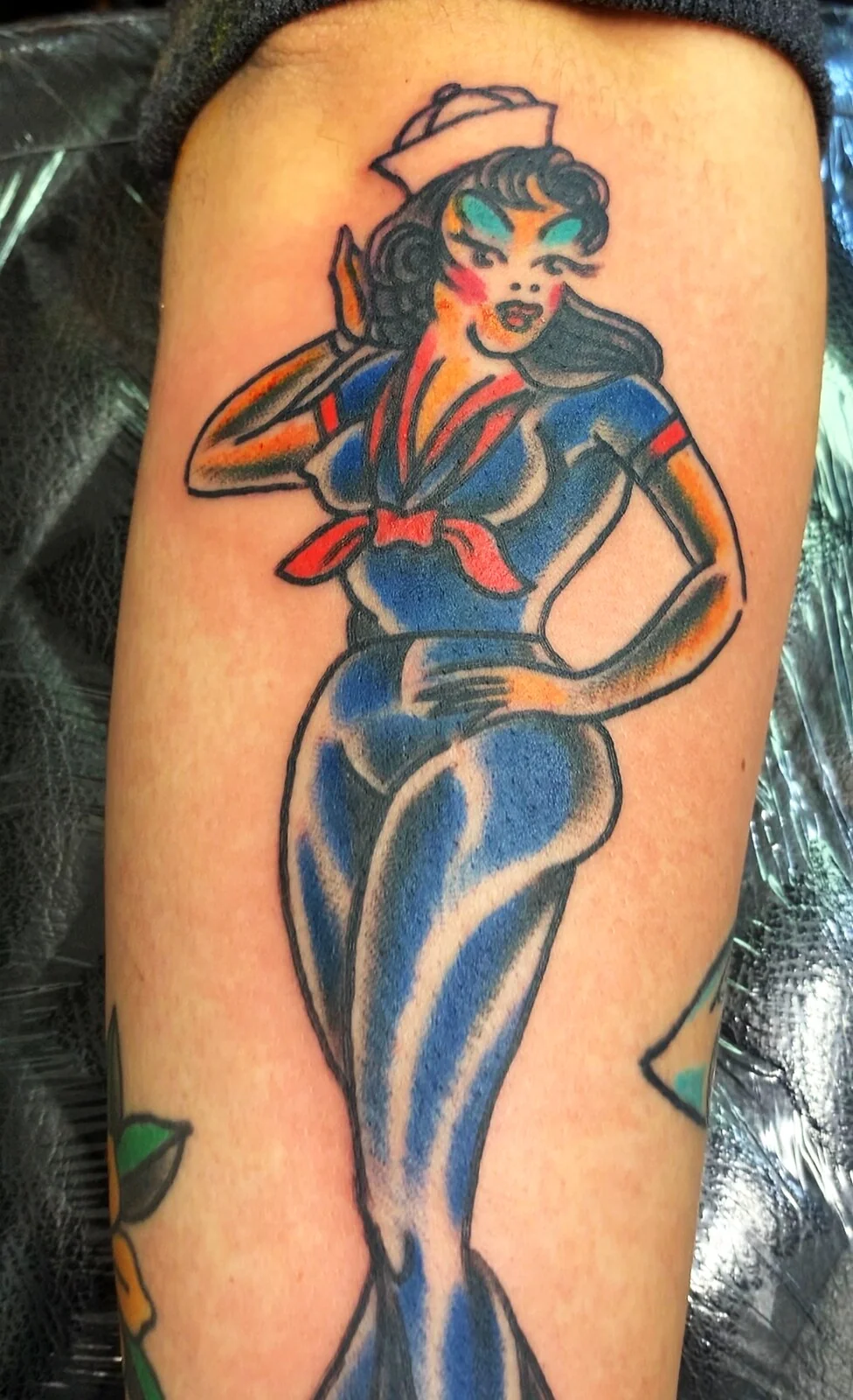 American Traditional sailor pin-up girl in blue dress arm tattoo by Tim Goodrich, Waikiki, Hawaii